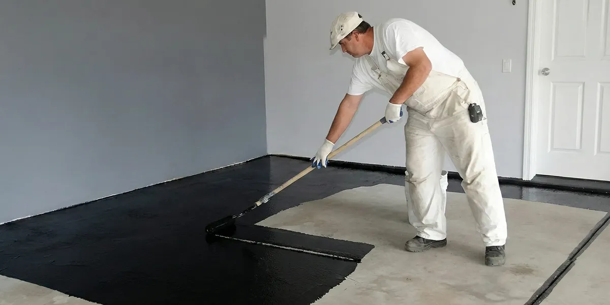 basement waterproofing professional applying waterproof coating to protect a basement floor in Savannah, GA
