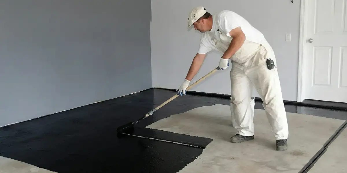 basement waterproofing professional applying waterproof coating to protect a basement floor in Savannah, GA